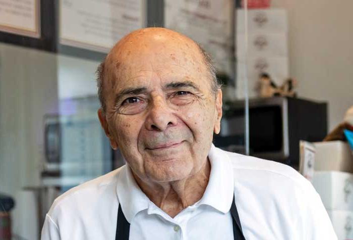 Photo of John Acampora at the counter of his Flat Breads shop